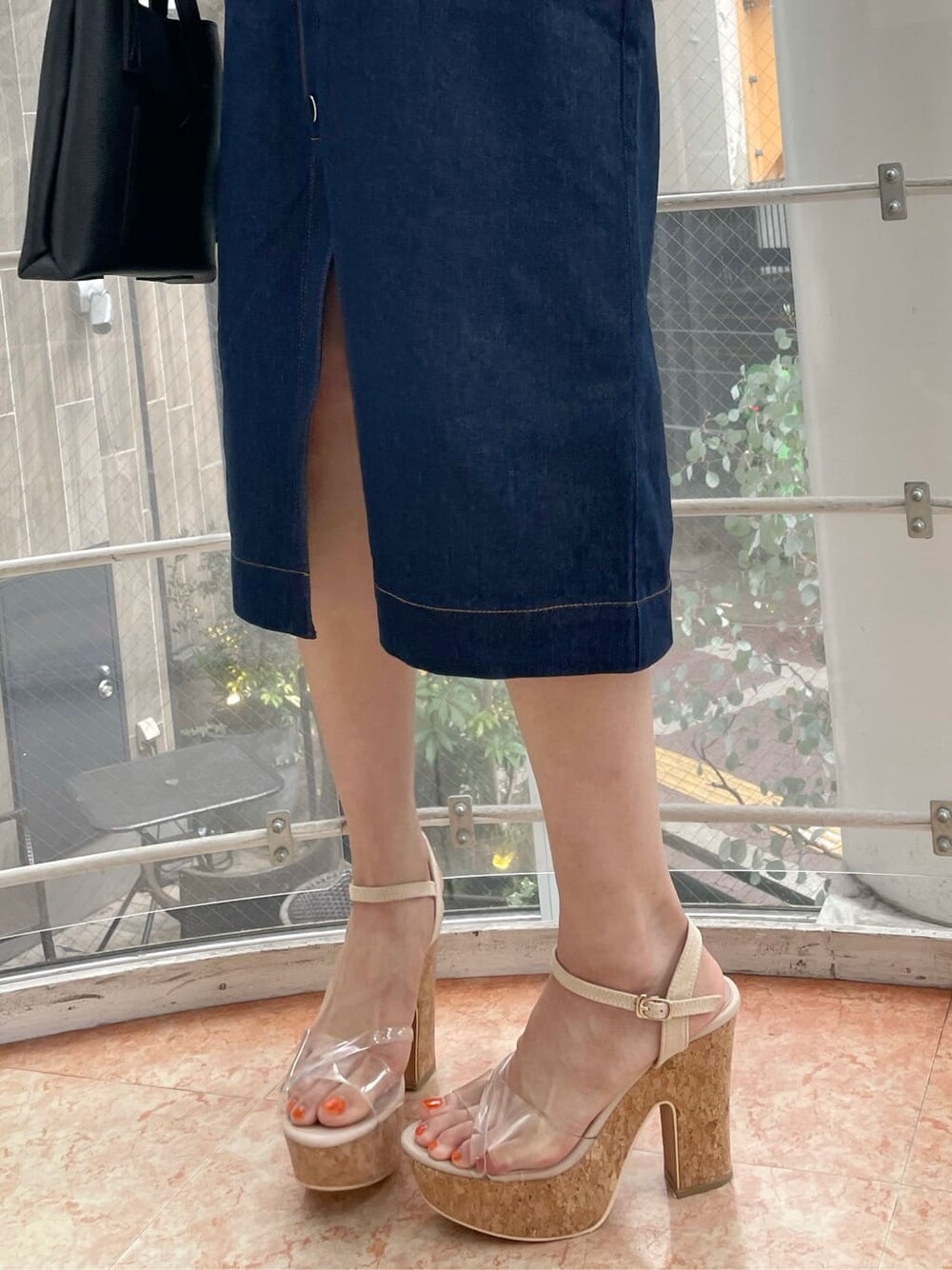 ブラック系のハンドバッグ、ブラック系のシャツ/ブラウス、ブルー系のスカートを着用したレディースの夏コーディネートの8枚目の写真