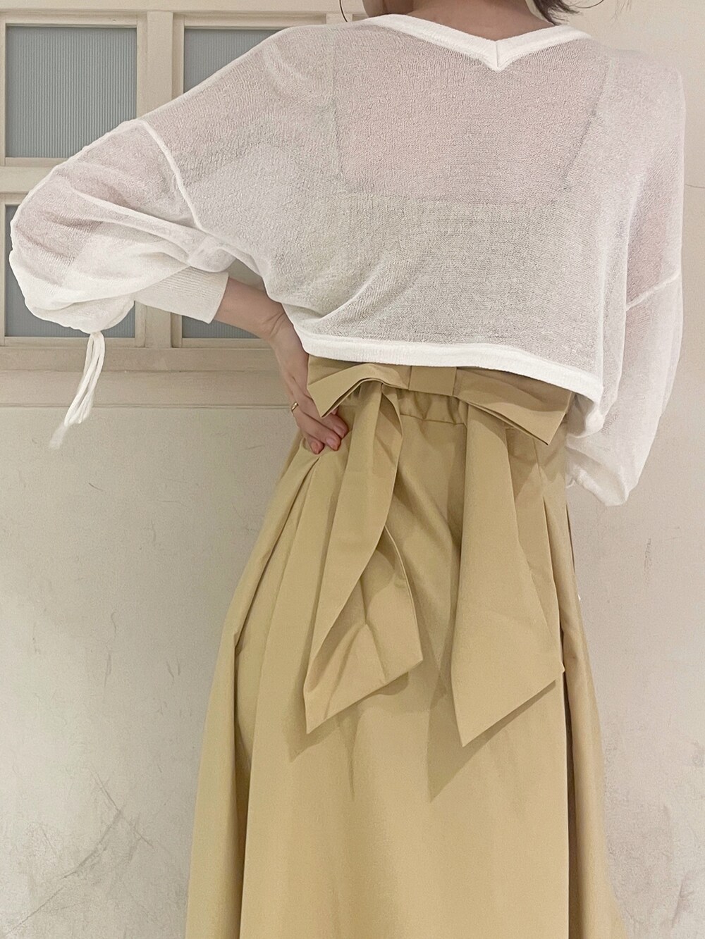 ホワイト系のカーディガン/ボレロ、イエロー系のワンピース、ホワイト系のハンドバッグを着用したレディースの夏コーディネートの6枚目の写真