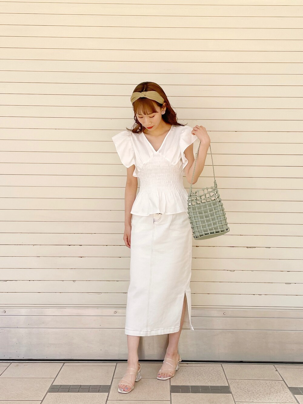 ホワイト系のシャツ/ブラウス、グリーン系のショルダーバッグ、ホワイト系のスカートを着用したレディースの春コーディネートの5枚目の写真