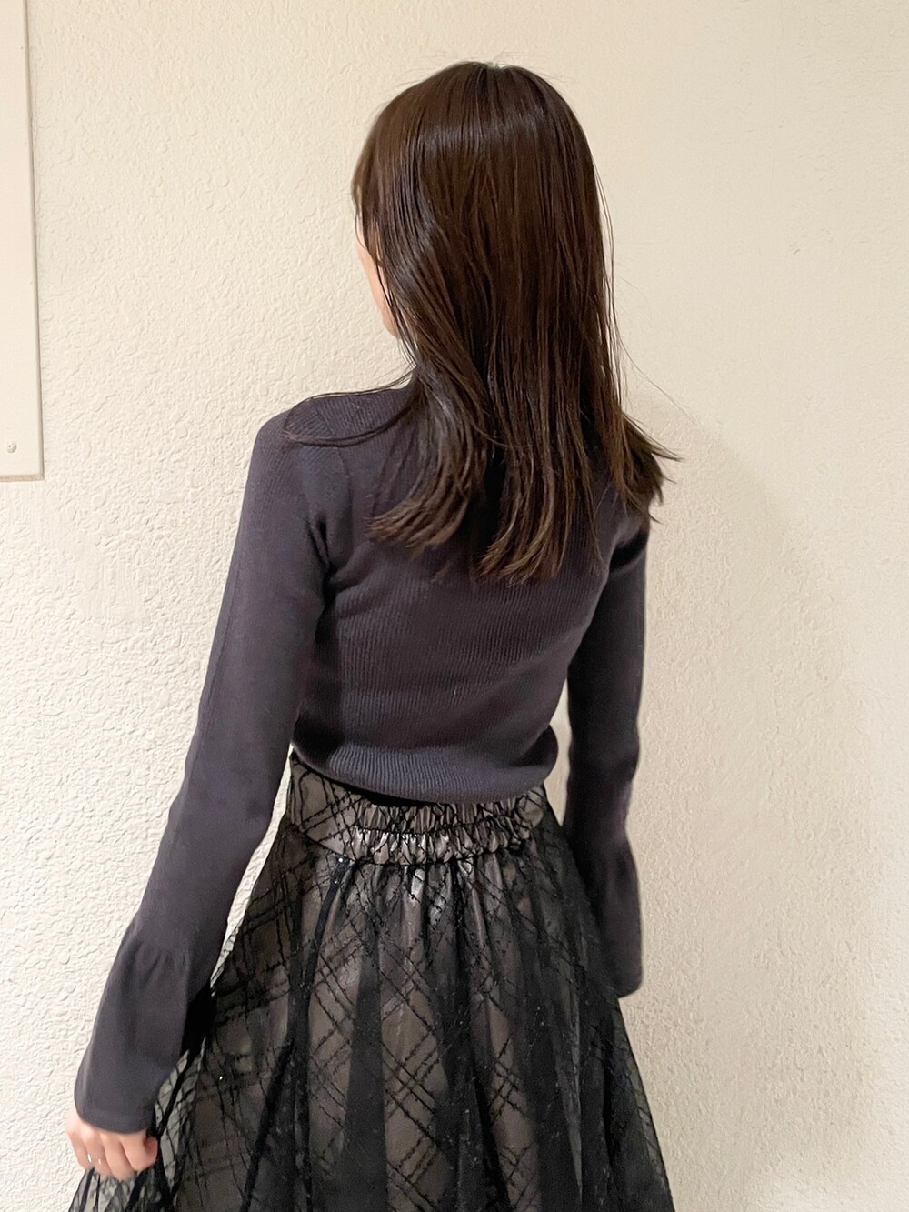 ブラック系のブーツ、ブラック系のニット/セーター、ブラック系のスカートを着用したレディースの冬コーディネートの5枚目の写真