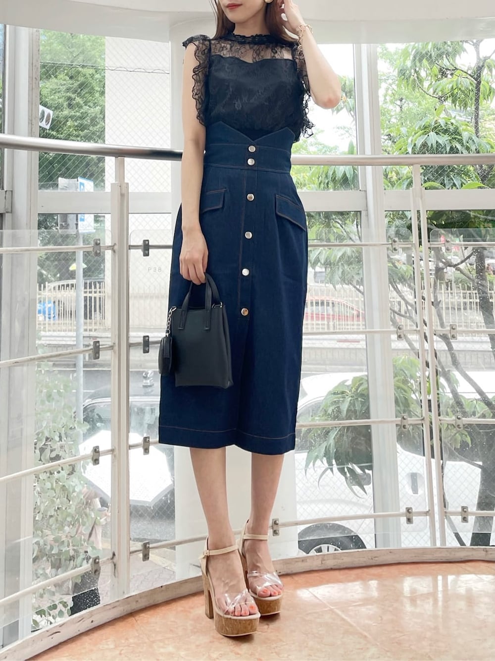 ブラック系のハンドバッグ、ブラック系のシャツ/ブラウス、ブルー系のスカートを着用したレディースの夏コーディネートの10枚目の写真