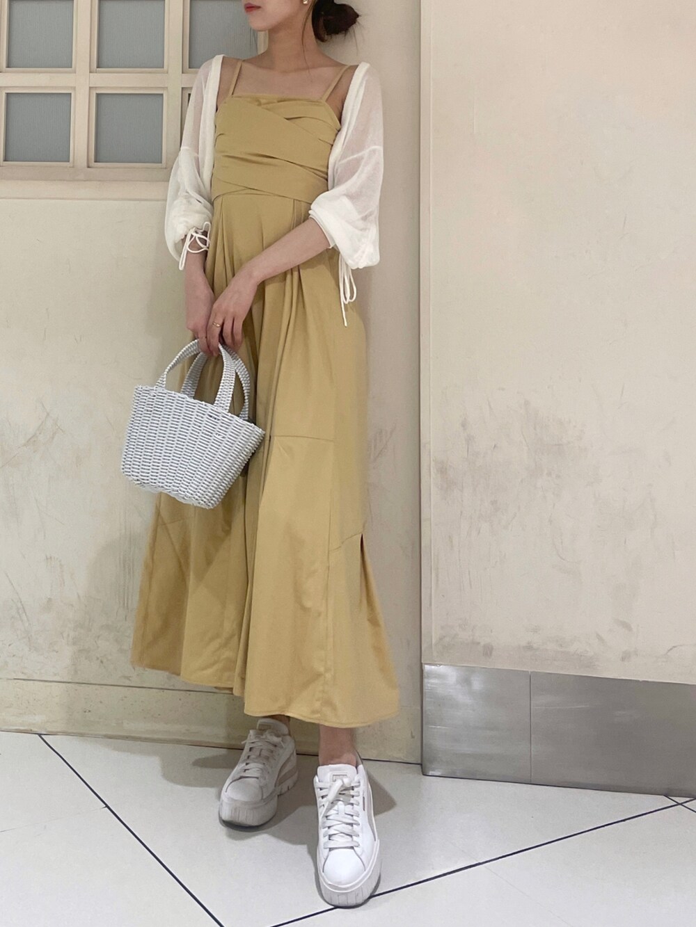ホワイト系のカーディガン/ボレロ、イエロー系のワンピース、ホワイト系のハンドバッグを着用したレディースの夏コーディネートの3枚目の写真