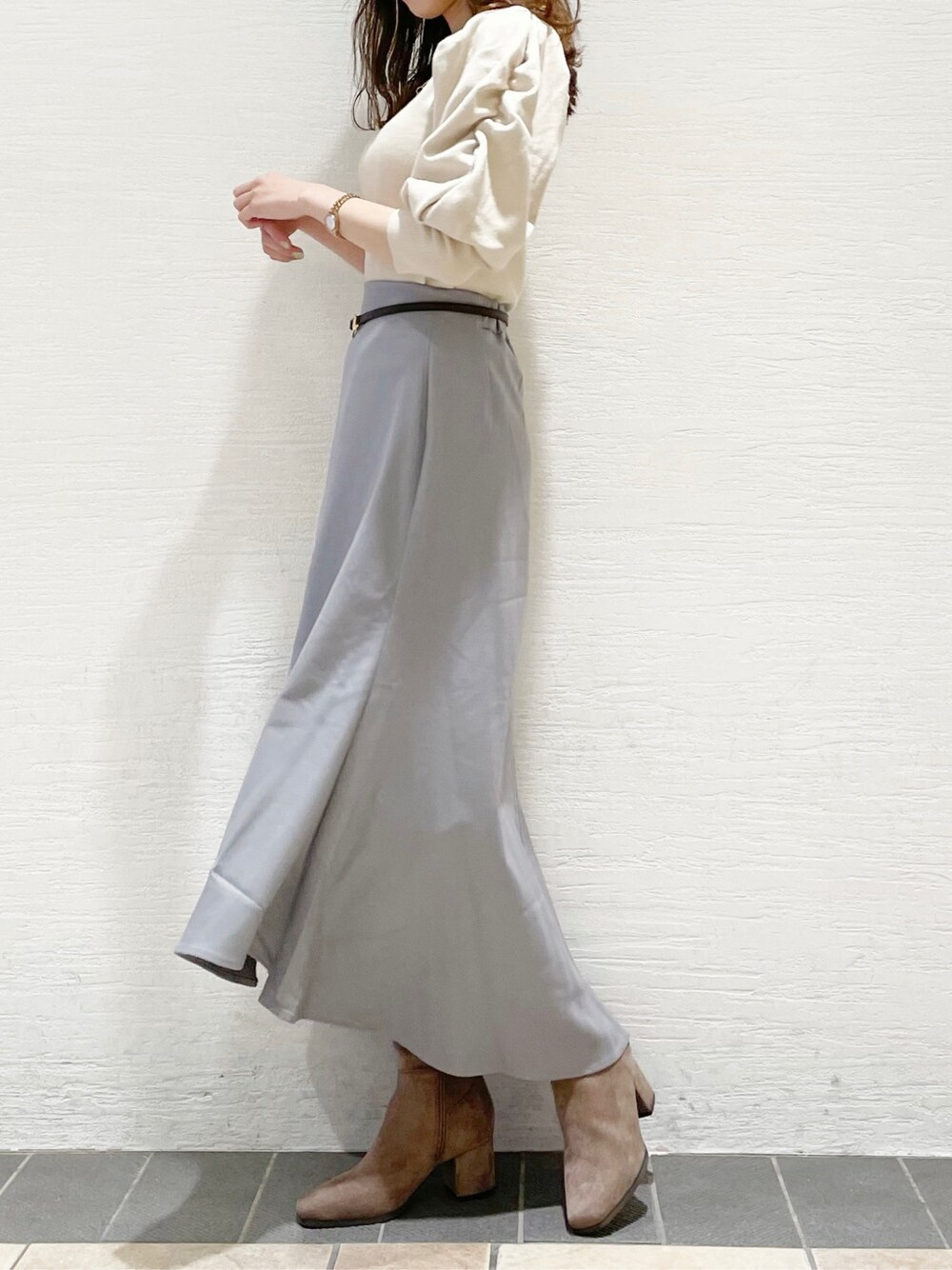 グレー系のスカート、ホワイト系のニット/セーター、ベージュ系のその他シューズを着用したレディースの冬コーディネートの3枚目の写真