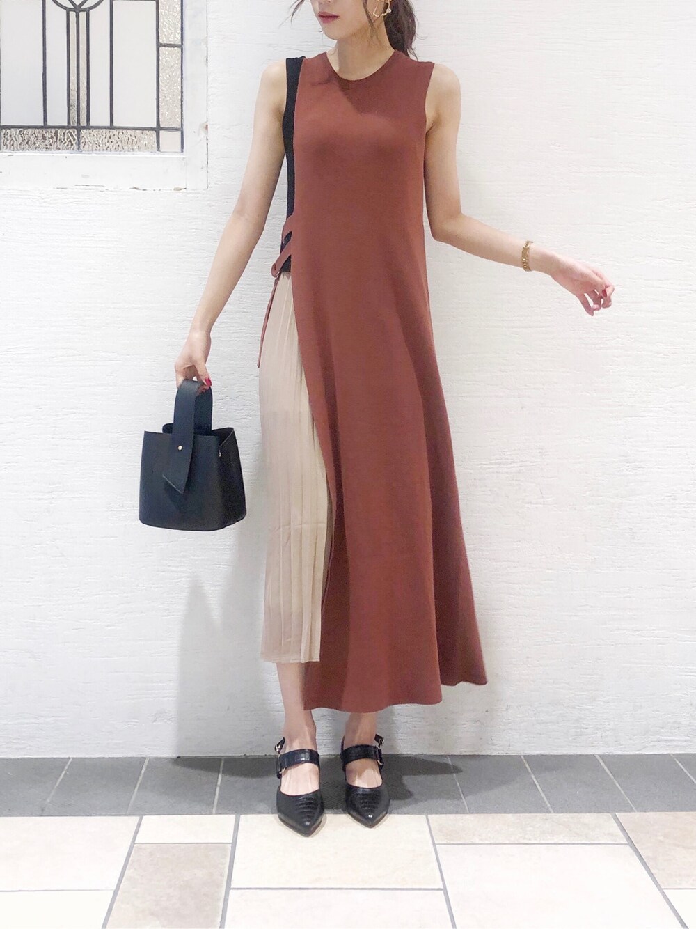 ブラック系のパンプス、ブラック系のハンドバッグ、ブラウン系のワンピースを着用したレディースの夏コーディネートの2枚目の写真