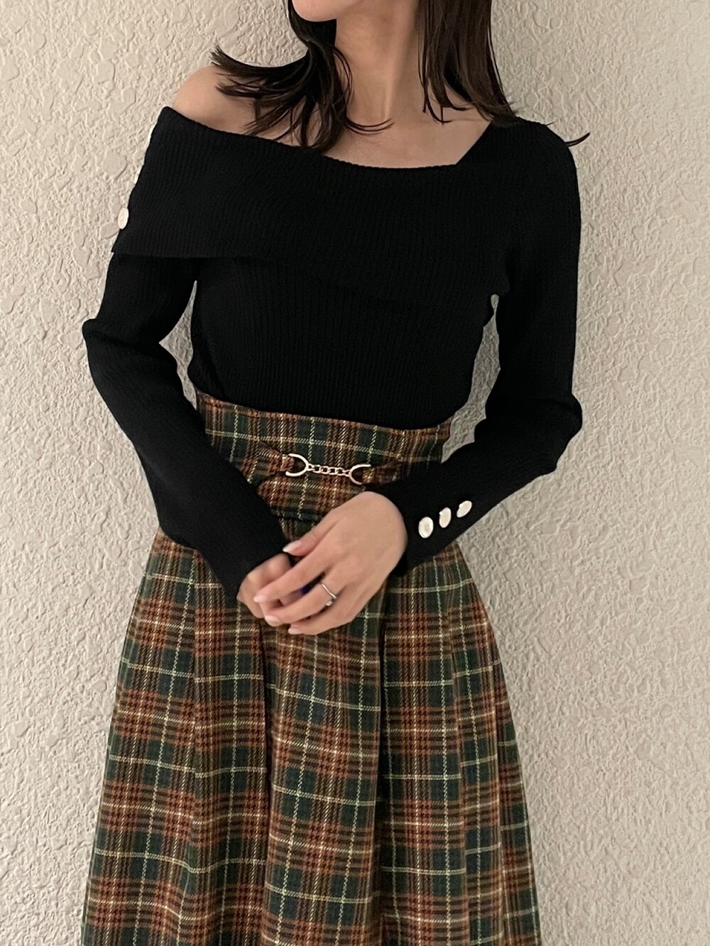 ブラック系のニット/セーター、ブラック系のブーツ、グリーン系のスカートを着用したレディースの秋コーディネートの6枚目の写真