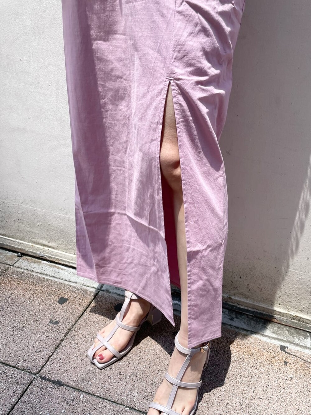 ブラック系のハンドバッグ、ピンク系のスカート、パープル系のサンダルを着用したレディースの夏コーディネートの9枚目の写真