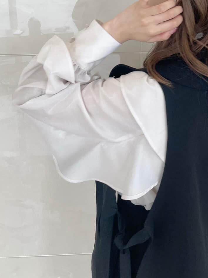 ホワイト系のシャツ/ブラウス、ブラック系のベスト、ブラック系のスカートを着用したレディースの秋コーディネートの6枚目の写真