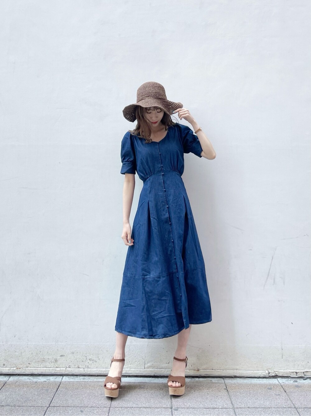 ブルー系のワンピース、ブラウン系のサンダル、ブラウン系のハットを着用したレディースの春コーディネートの2枚目の写真
