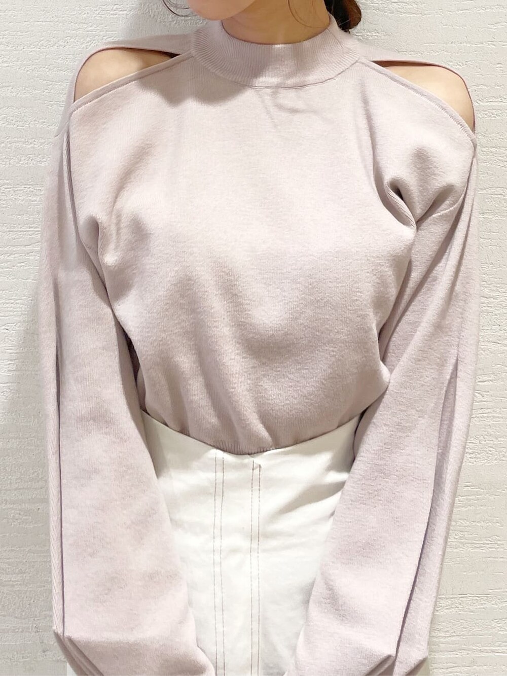 ベージュ系のニット/セーター、ブルー系のハンドバッグ、ベージュ系のブーツを着用したレディースの冬コーディネートの5枚目の写真