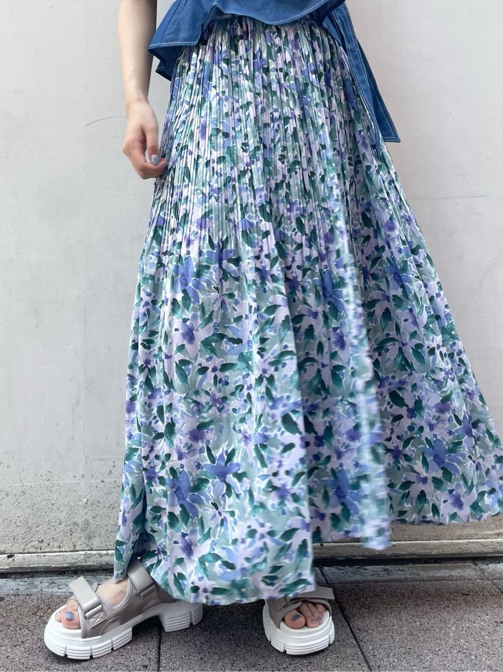 ブルー系のスカート、ベージュ系のサンダル、ブルー系のシャツ/ブラウスを着用したレディースの夏コーディネートの7枚目の写真