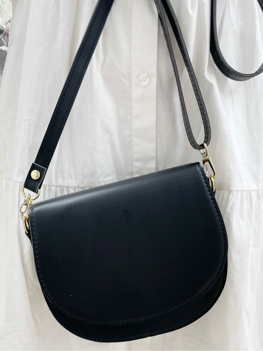 ホワイト系のワンピース、ブラック系のショルダーバッグ、ベージュ系のニット/セーターを着用したレディースの秋コーディネートの10枚目の写真