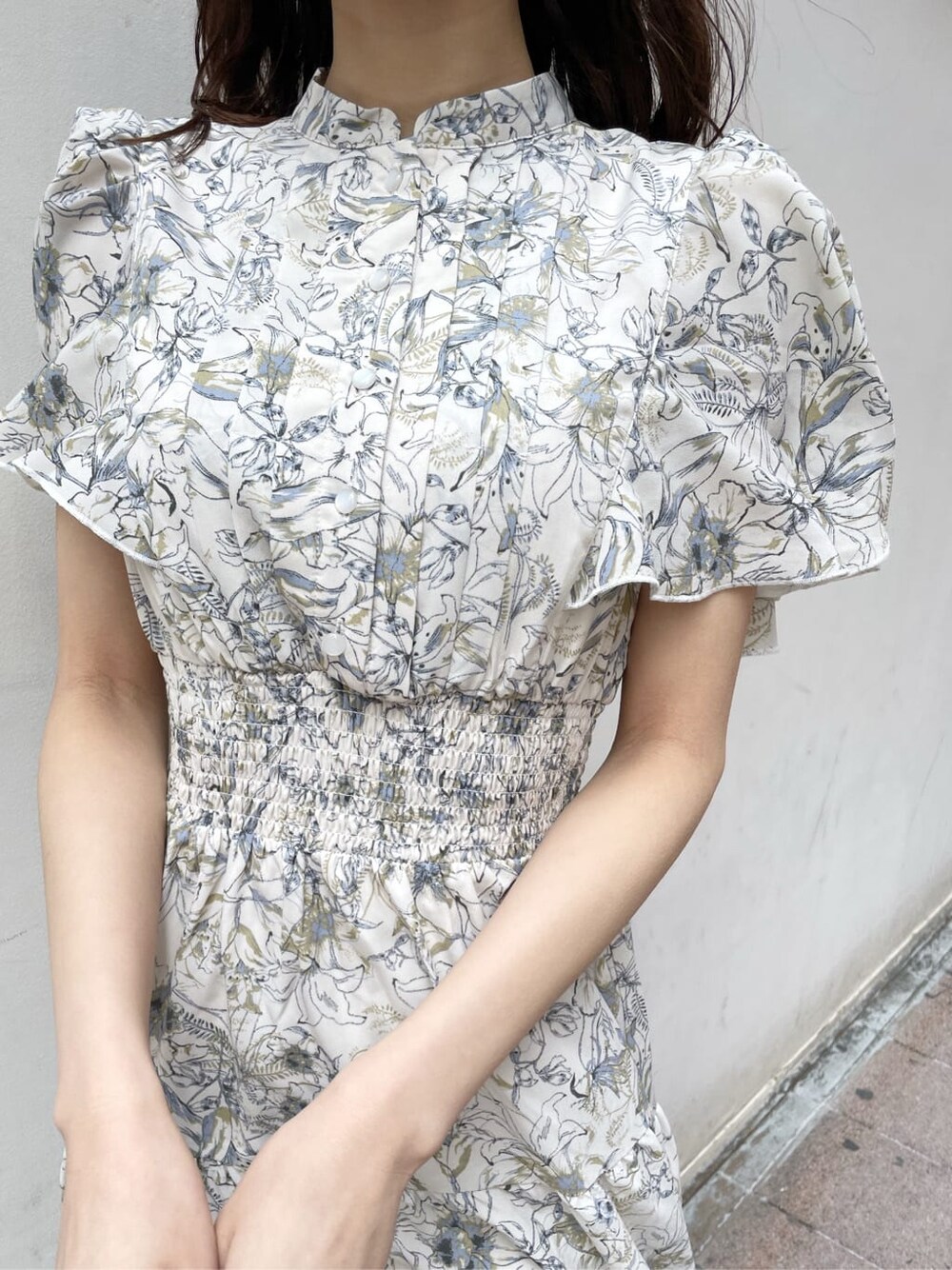 ベージュ系のトレンチコート、ホワイト系のワンピース、ベージュ系のブーツを着用したレディースの春コーディネートの7枚目の写真