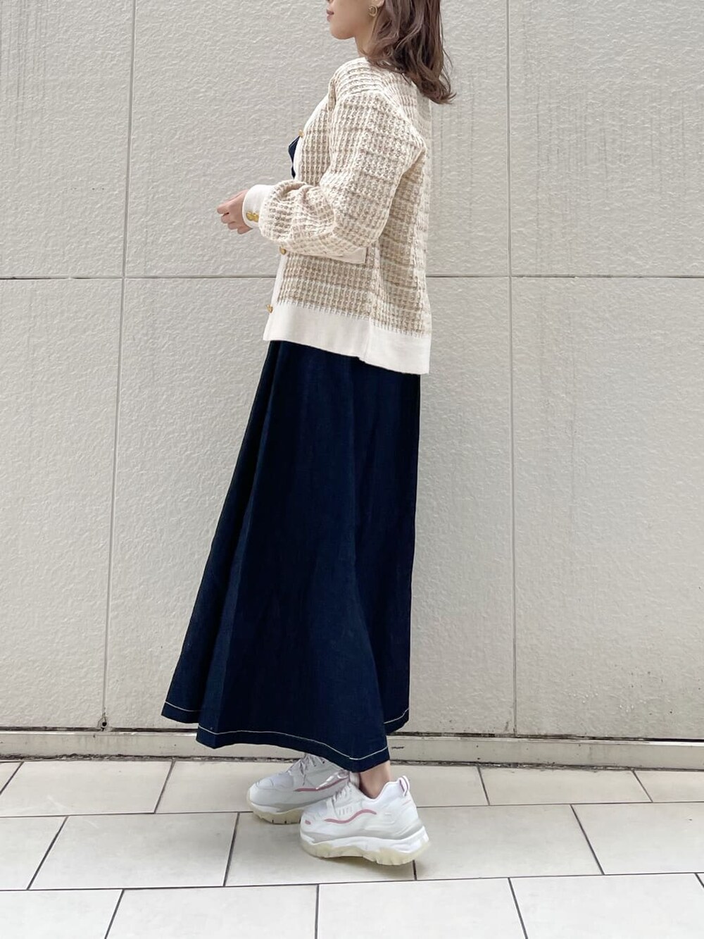 ピンク系のスニーカー、ブルー系のワンピース、ベージュ系のカーディガン/ボレロを着用したレディースの冬コーディネートの4枚目の写真