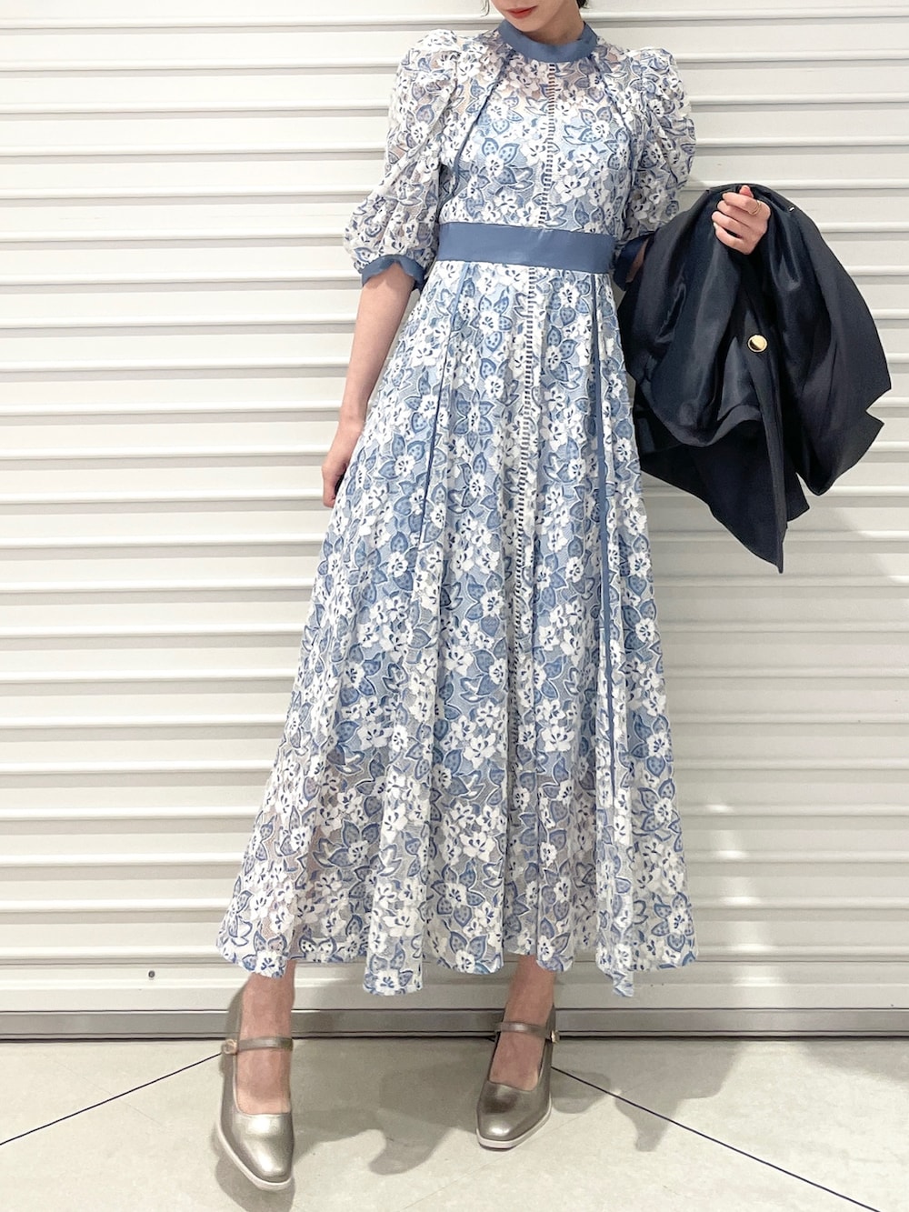 ブルー系のワンピース、シルバー系のパンプス、グレー系のテーラードジャケットを着用したレディースの冬コーディネートの5枚目の写真