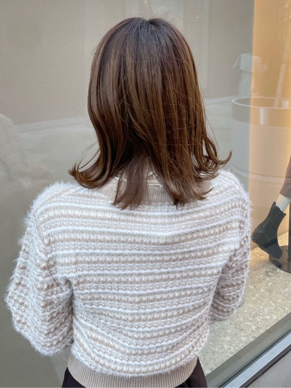 ブラウン系のスカート、ブラック系のブーツ、ベージュ系のカーディガン/ボレロを着用したレディースの秋コーディネートの6枚目の写真