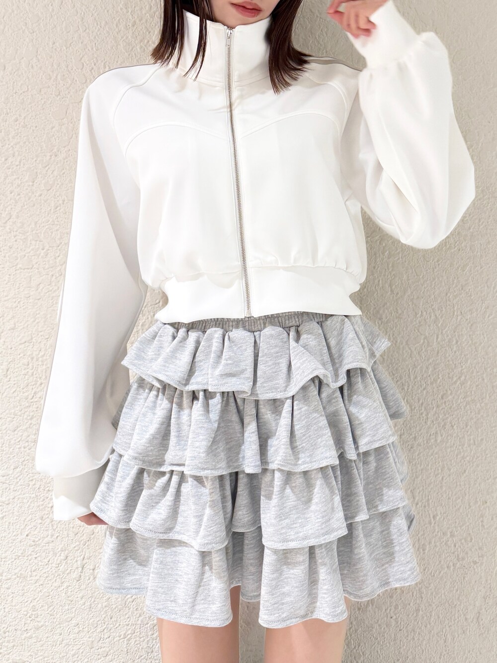 ブラック系のブーツ、グレー系のスカート、ホワイト系のその他アウターを着用したレディースの春コーディネートの5枚目の写真