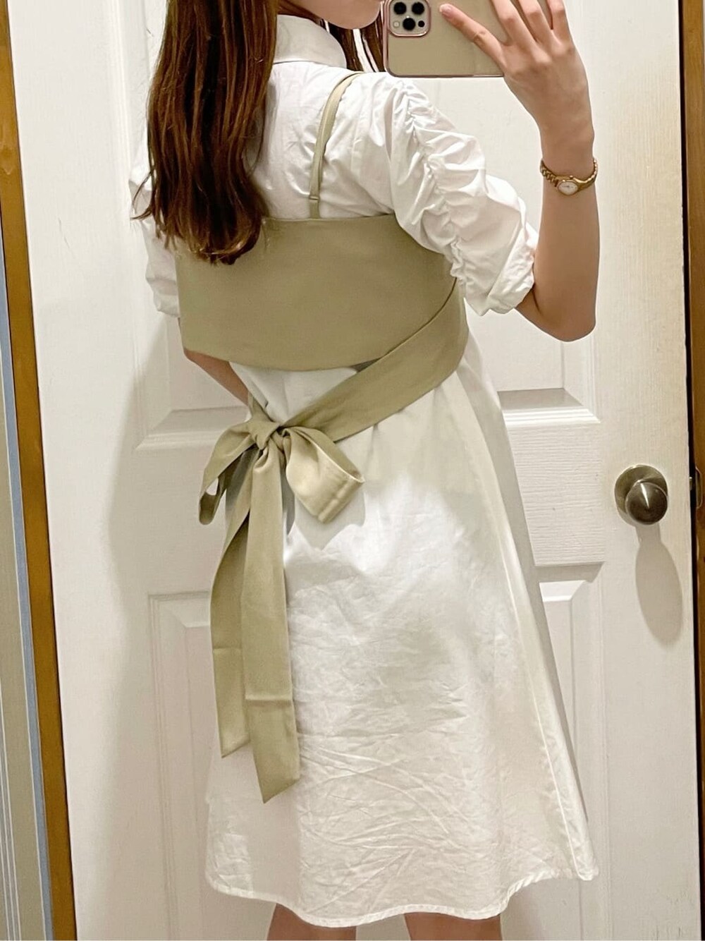 ブラック系のサンダル、ホワイト系のシャツワンピース、ブラウン系のイヤリングを着用したレディースの夏コーディネートの3枚目の写真