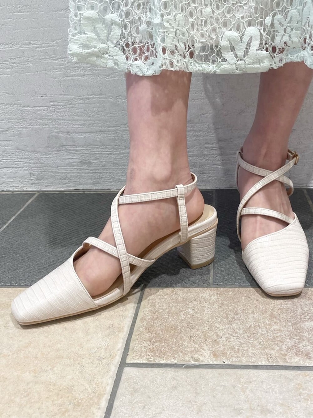 ホワイト系のニット/セーター、ブルー系のスカート、ブルー系のハンドバッグを着用したレディースの春コーディネートの8枚目の写真