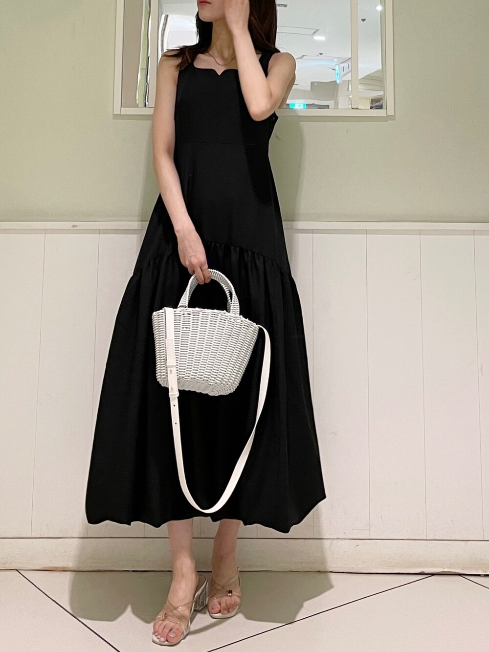 ブラック系のワンピース、ホワイト系のサンダル、ホワイト系のハンドバッグを着用したレディースの夏コーディネートの3枚目の写真