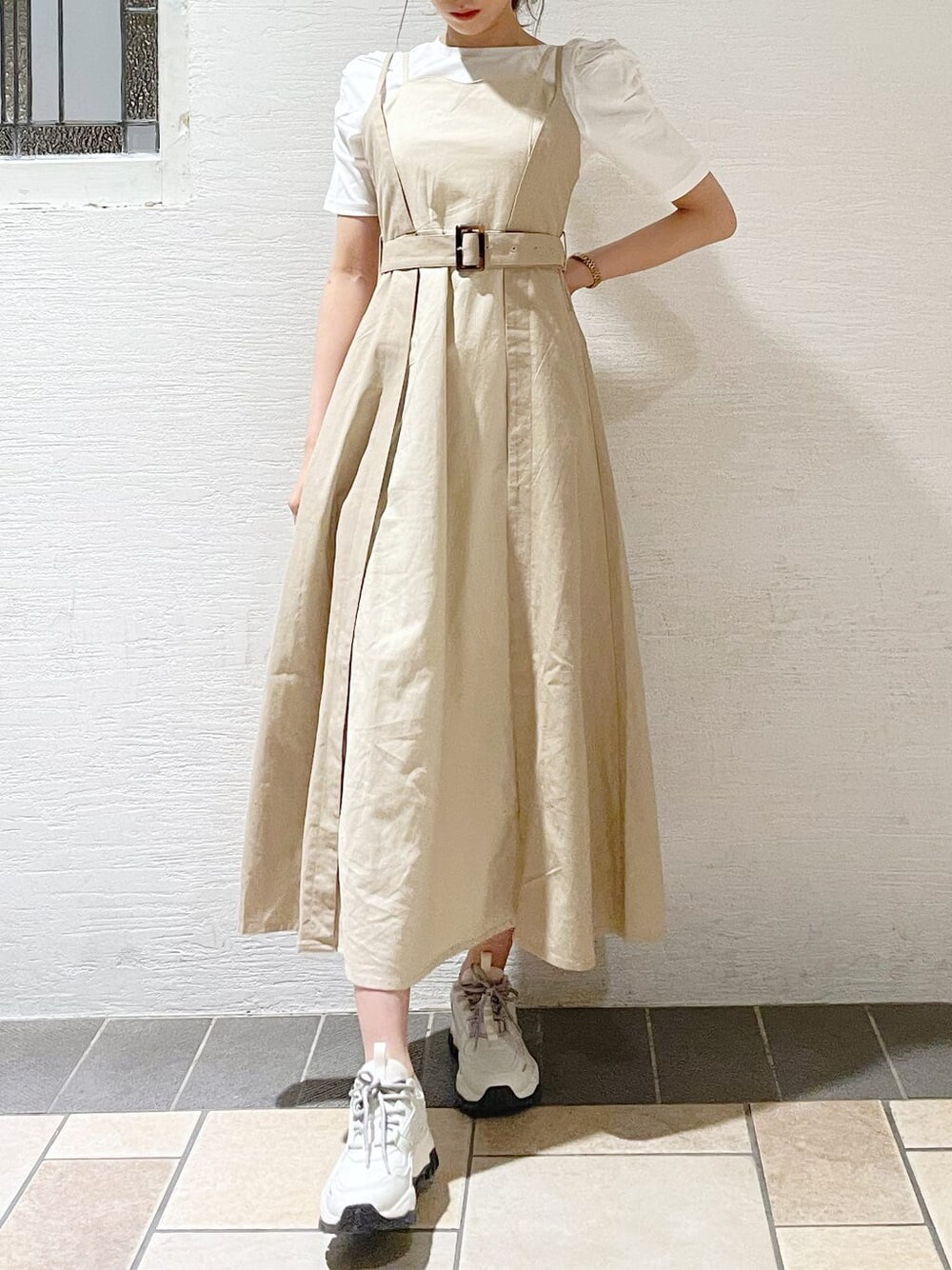 ホワイト系のスニーカー、ベージュ系のワンピース、ホワイト系のTシャツ/カットソーを着用したレディースの春コーディネートの5枚目の写真