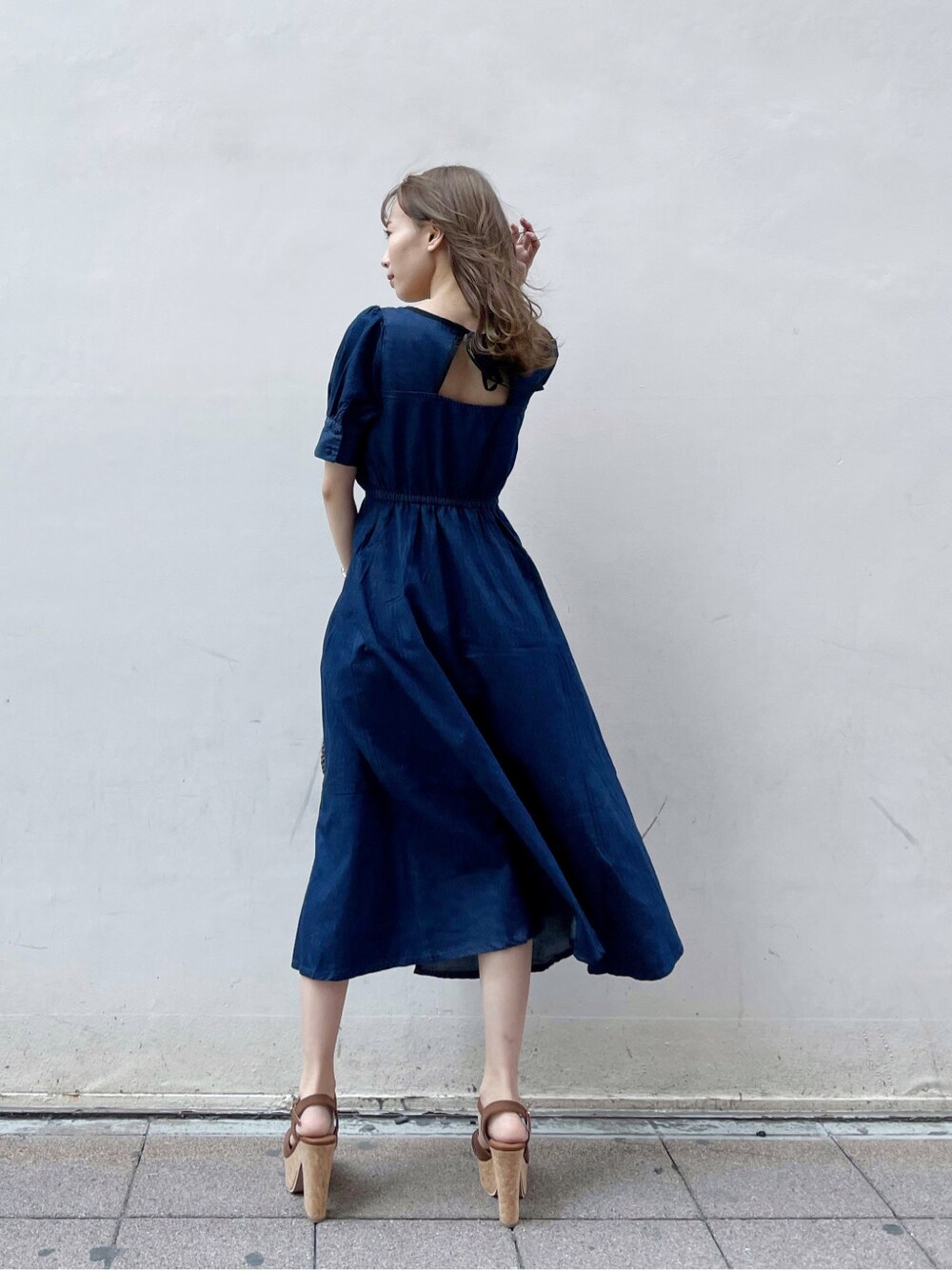 ブルー系のワンピース、ブラウン系のサンダル、ブラウン系のハットを着用したレディースの春コーディネートの3枚目の写真