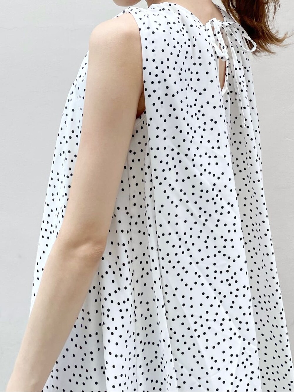 オレンジ系のサンダル、ホワイト系のワンピース、ゴールド系のブレスレットを着用したレディースの夏コーディネートの6枚目の写真