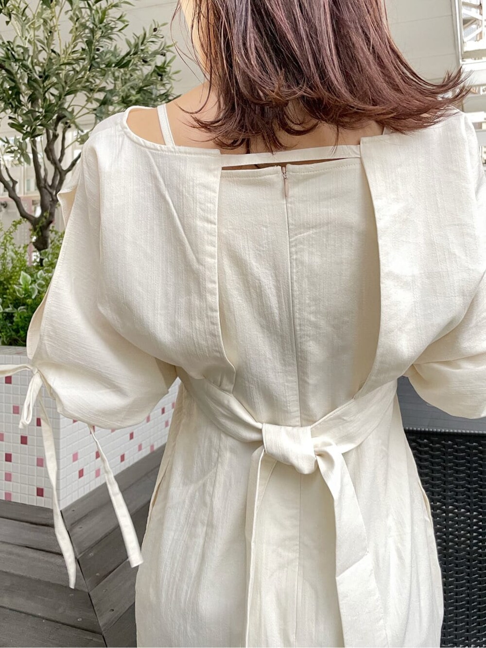 ベージュ系のデニムジャケット、ホワイト系のワンピース、ホワイト系のローファーを着用したレディースの春コーディネートの6枚目の写真