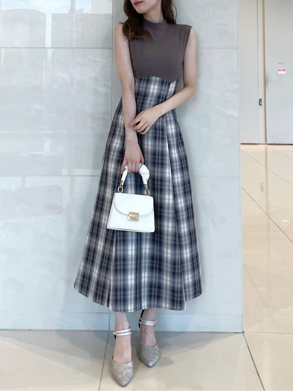 ベージュ系のワンピース、パープル系のライダースジャケット、グレー系のパンプスを着用したレディースの秋コーディネートの5枚目の写真