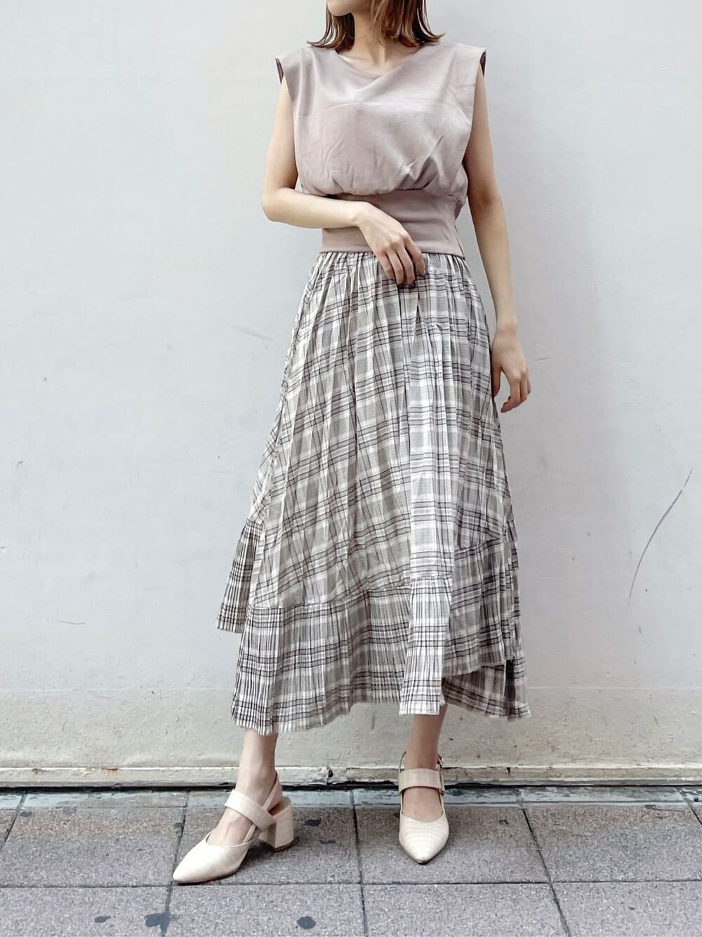 ベージュ系のスカート、ブラウン系のTシャツ/カットソーを着用したレディースの夏コーディネートの2枚目の写真