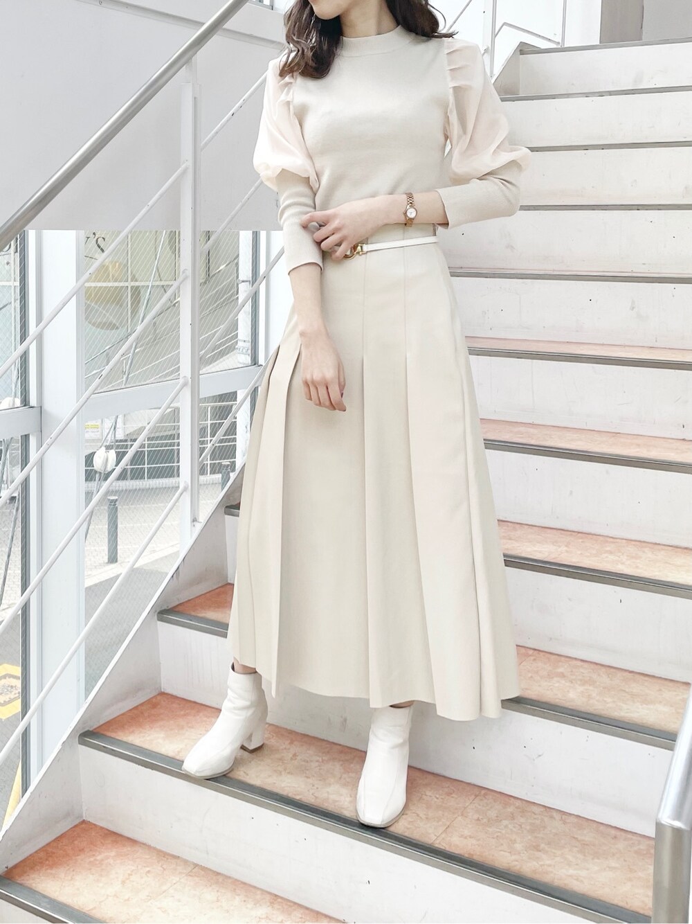 ホワイト系のニット/セーター、ホワイト系のブーツ、ベージュ系のスカートを着用したレディースの冬コーディネートの2枚目の写真
