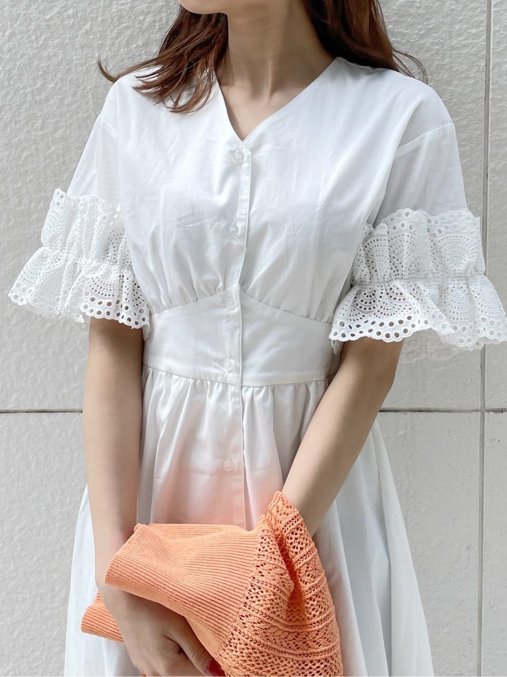 ホワイト系のワンピース、ベージュ系のサンダル、オレンジ系のカーディガン/ボレロを着用したレディースの春コーディネートの6枚目の写真