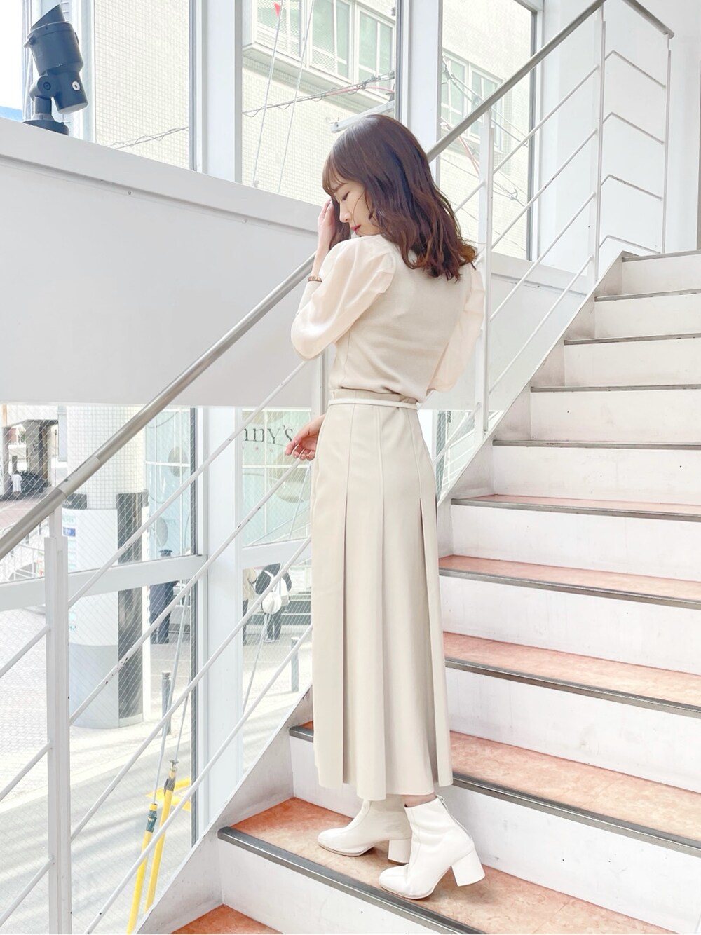 ホワイト系のニット/セーター、ホワイト系のブーツ、ベージュ系のスカートを着用したレディースの冬コーディネートの5枚目の写真