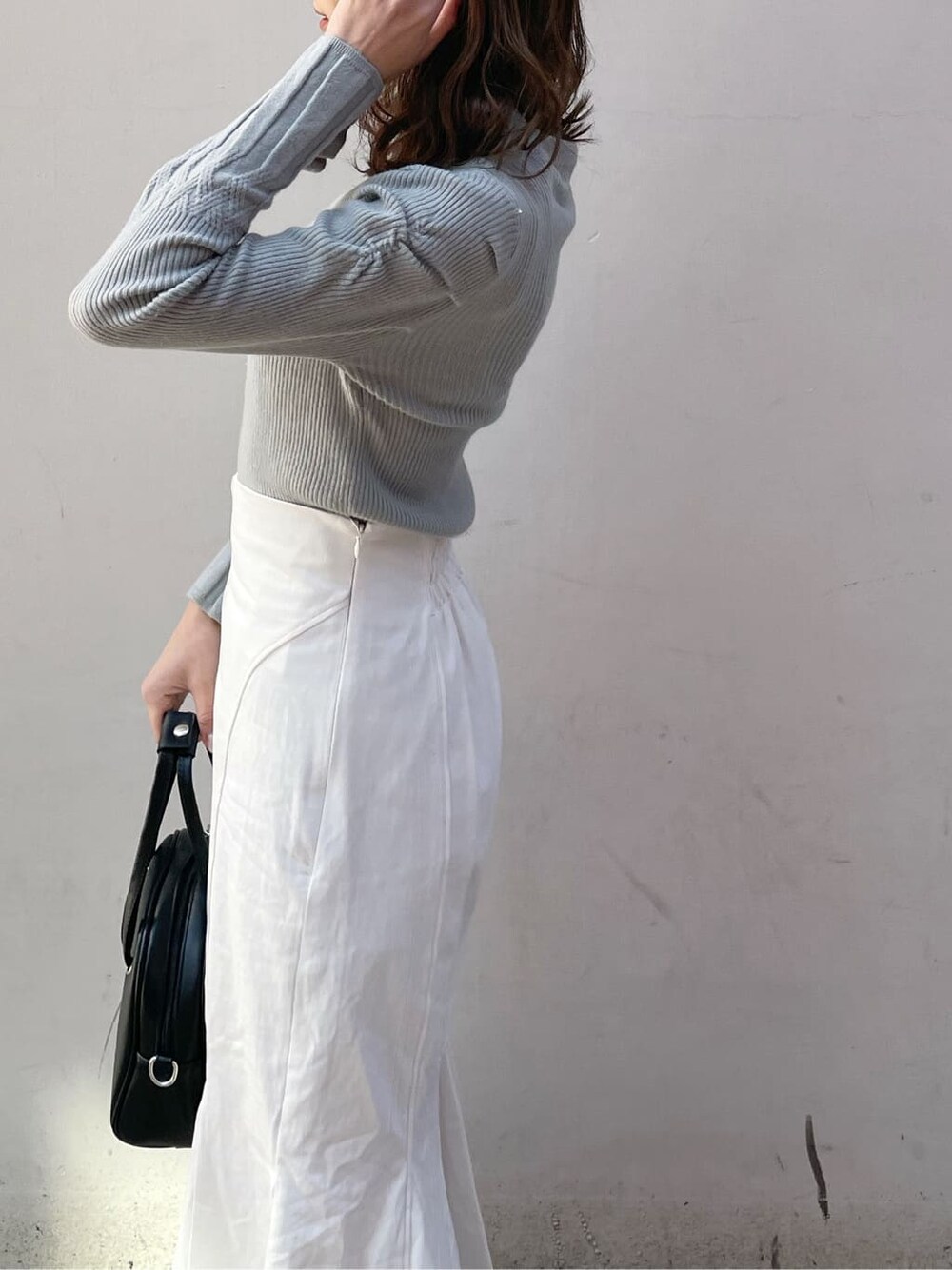 ホワイト系のスカート、ブラック系のブーツ、グリーン系のニット/セーターを着用したレディースの冬コーディネートの4枚目の写真