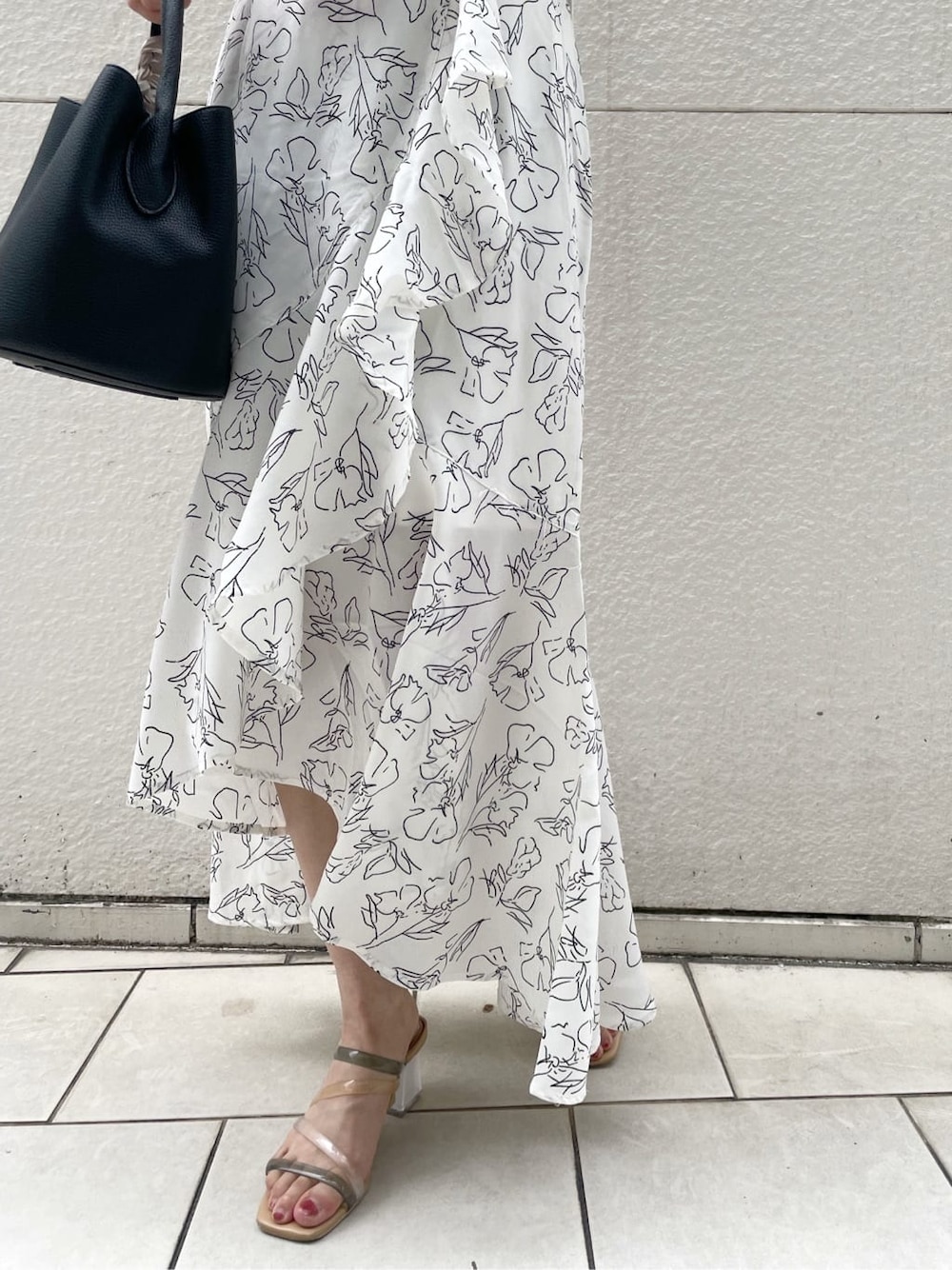 その他のサンダル、ホワイト系のスカート、ブラック系のハンドバッグを着用したレディースの夏コーディネートの9枚目の写真