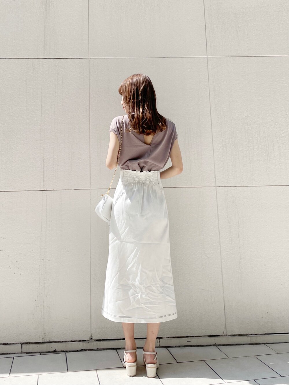 ホワイト系のスカート、ホワイト系のパンプス、ホワイト系のショルダーバッグを着用したレディースの春コーディネートの9枚目の写真