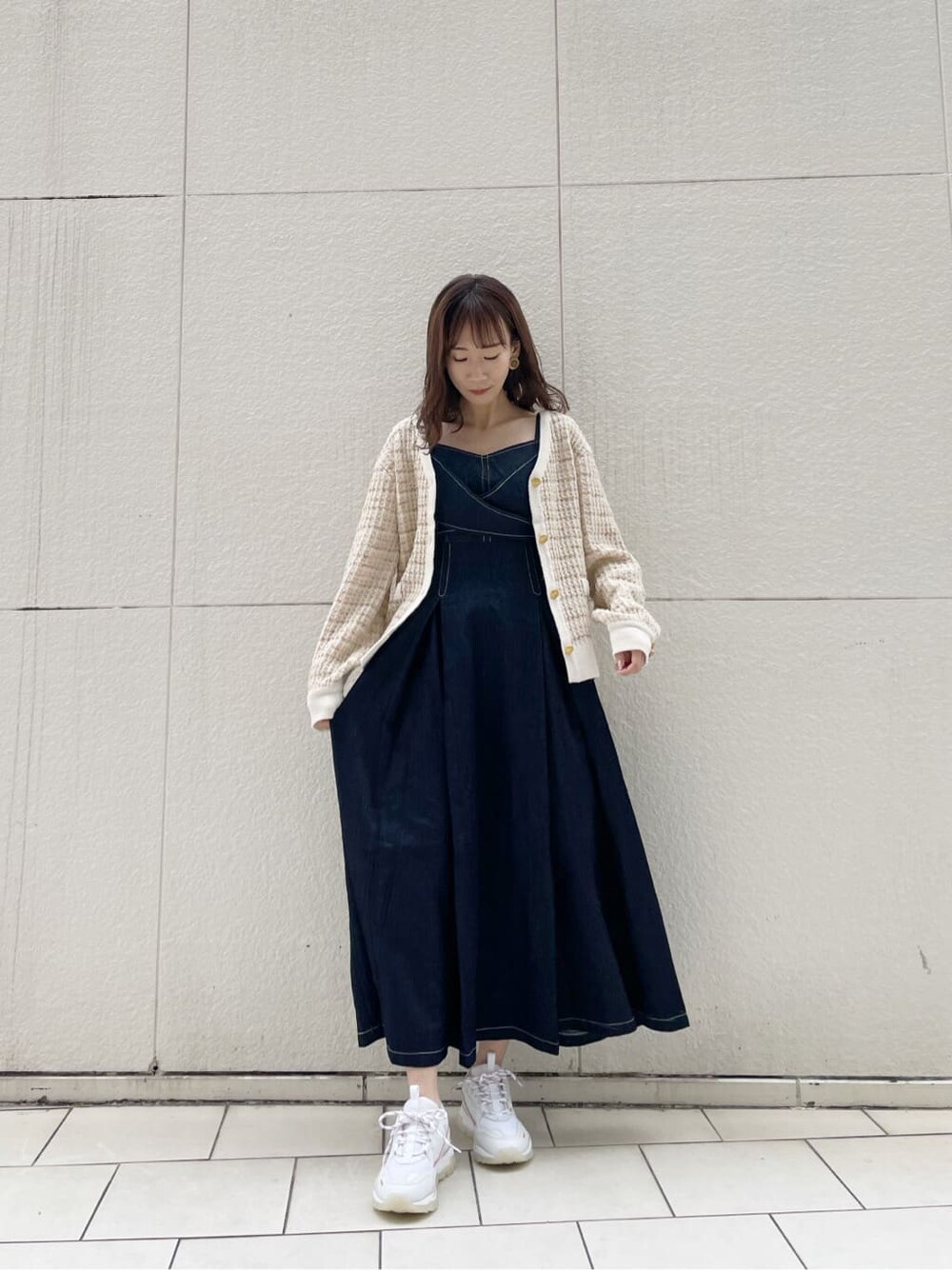 ピンク系のスニーカー、ブルー系のワンピース、ベージュ系のカーディガン/ボレロを着用したレディースの冬コーディネートの2枚目の写真