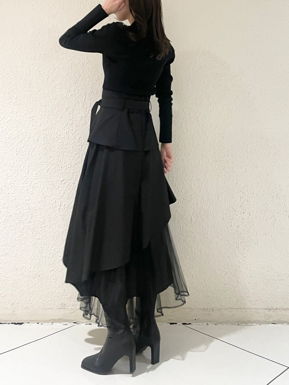 ブラック系のニット/セーター、ブラック系のブーツ、ブラック系のスカートを着用したレディースの冬コーディネートの3枚目の写真