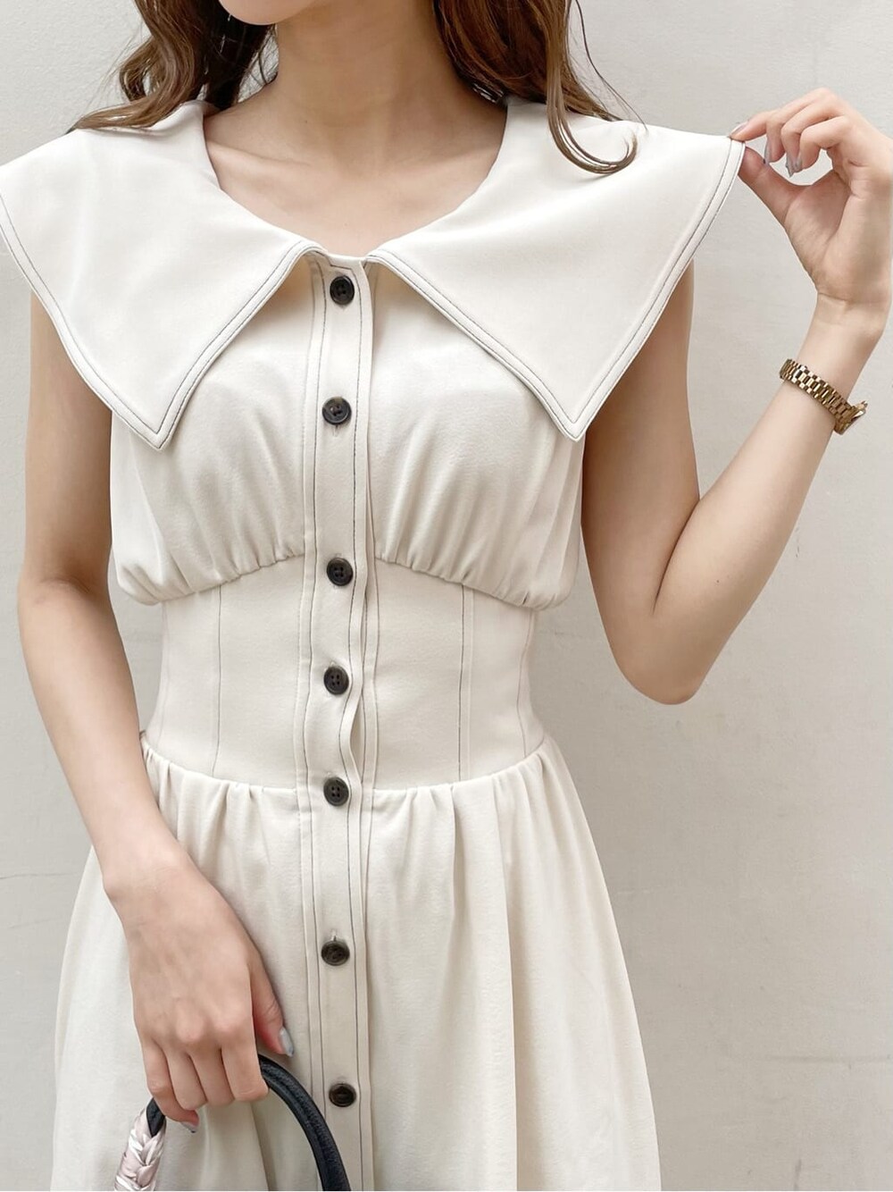 ブラック系のサンダル、ブラック系のハンドバッグ、ホワイト系のワンピースを着用したレディースの春コーディネートの4枚目の写真