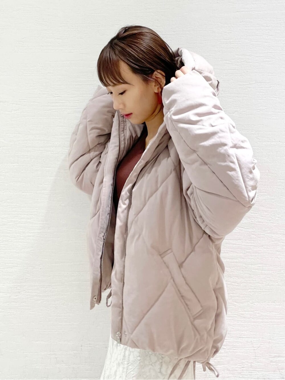 ホワイト系のスカート、ピンク系のダウンジャケット/コート、ブラウン系のニット/セーターを着用したレディースの夏コーディネートの4枚目の写真