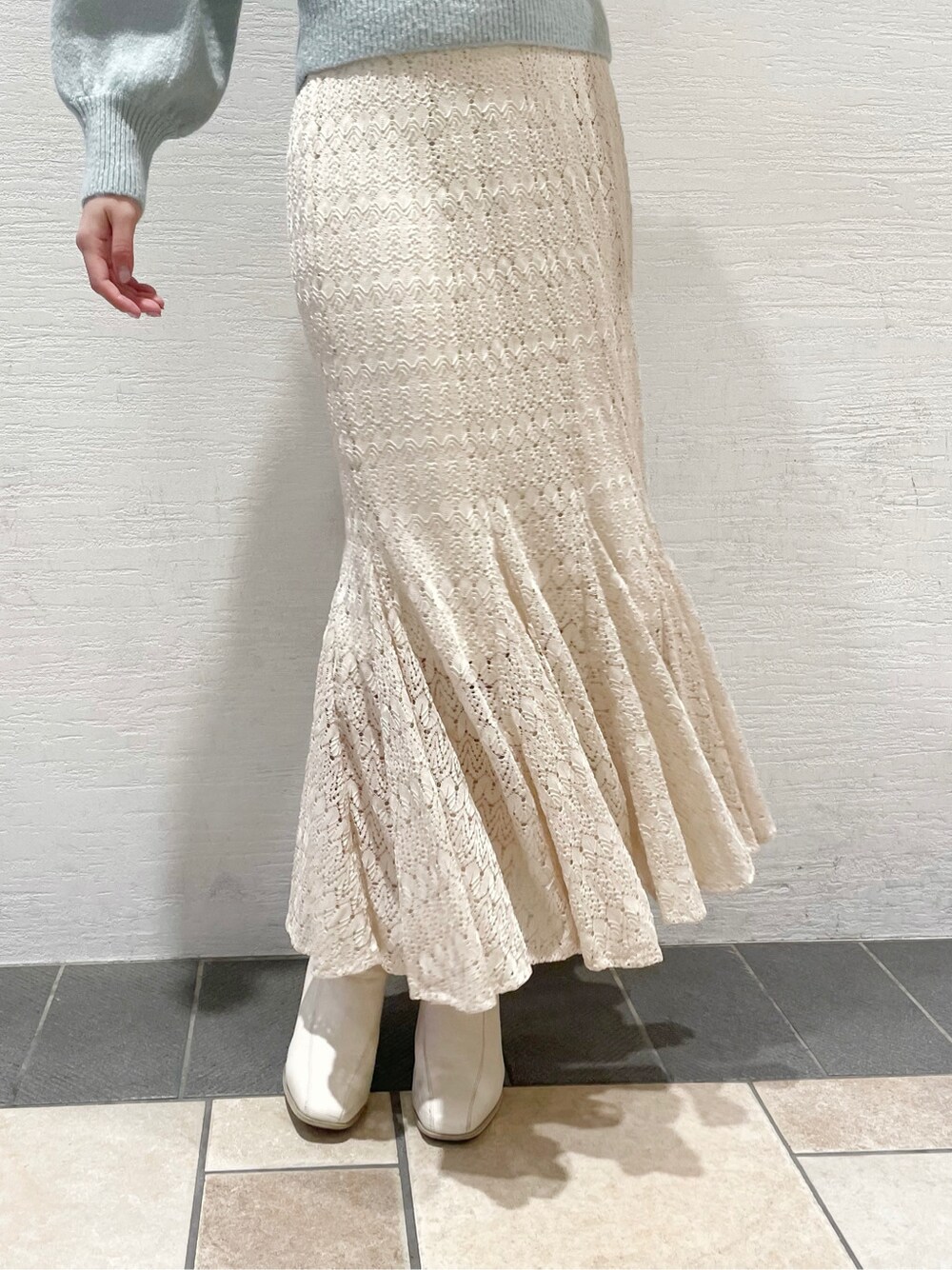 ホワイト系のスカート、ホワイト系のブーツ、ブルー系のニット/セーターを着用したレディースの冬コーディネートの7枚目の写真