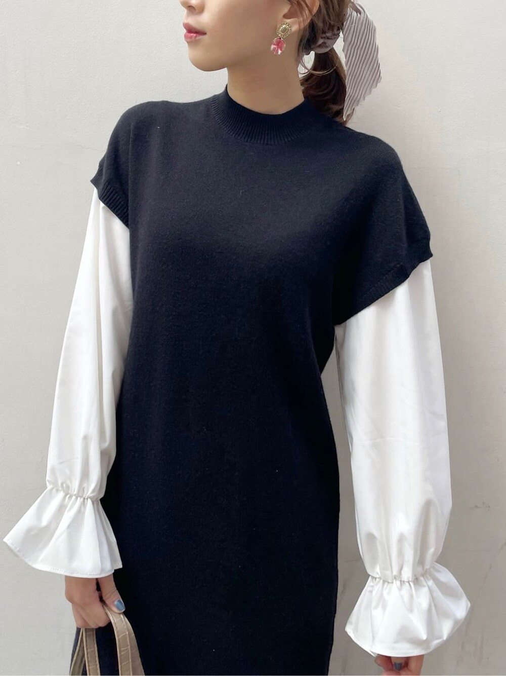 ブラック系のブーツ、ブラック系のワンピース、ベージュ系のハンドバッグを着用したレディースの秋コーディネートの5枚目の写真