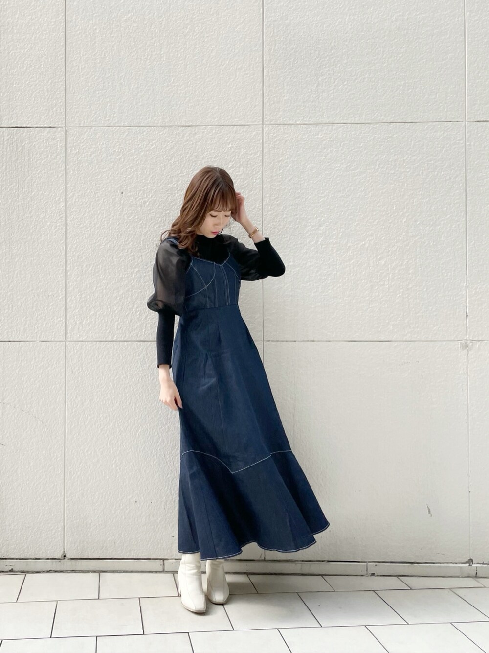 ホワイト系のブーツ、ブラック系のニット/セーター、ブルー系のワンピースを着用したレディースの冬コーディネートの5枚目の写真