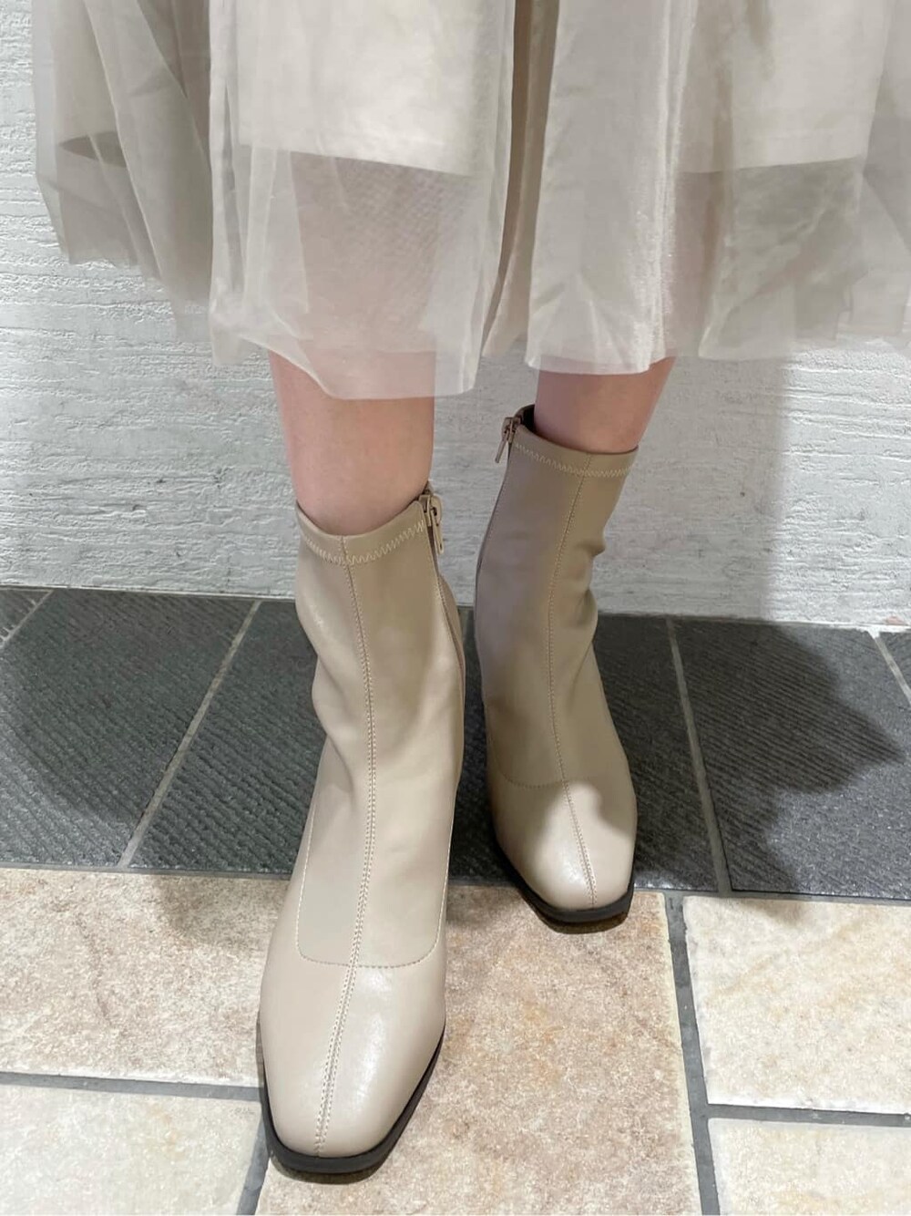 ベージュ系のスカート、ホワイト系のブルゾン、ブラウン系のニット/セーターを着用したレディースの夏コーディネートの10枚目の写真