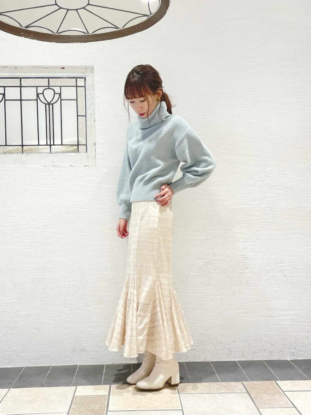 ホワイト系のスカート、ホワイト系のブーツ、ブルー系のニット/セーターを着用したレディースの冬コーディネートの3枚目の写真