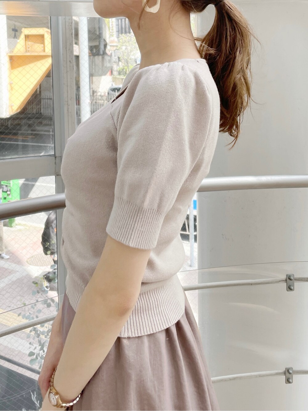 ブラウン系のスカート、ベージュ系のサンダル、ホワイト系のハンドバッグを着用したレディースの春コーディネートの6枚目の写真