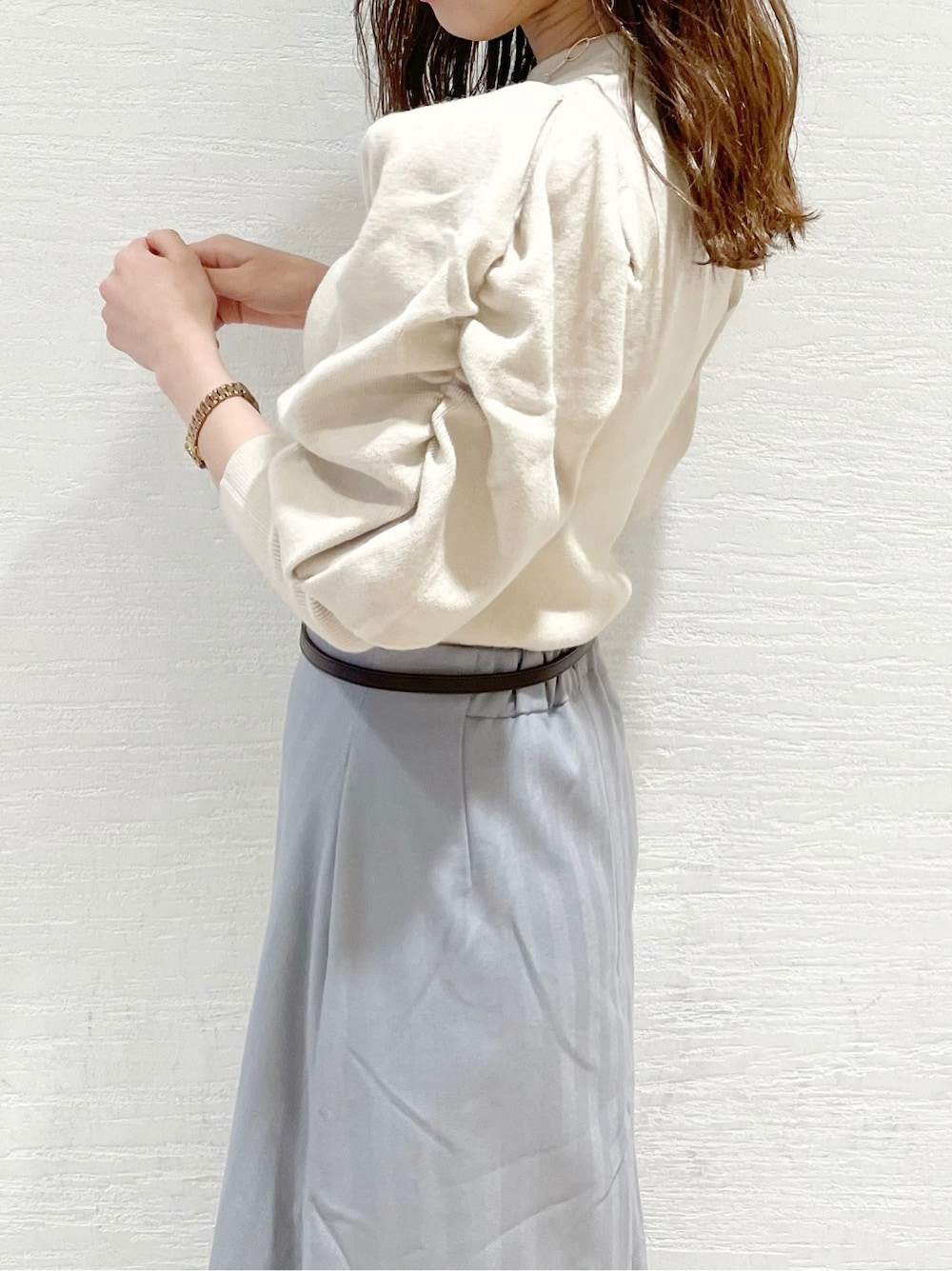 グレー系のスカート、ホワイト系のニット/セーター、ベージュ系のその他シューズを着用したレディースの冬コーディネートの5枚目の写真