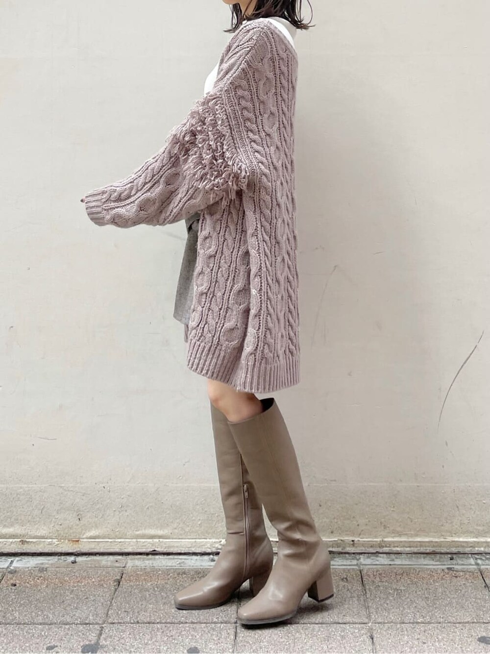 ブラウン系のスカート、ベージュ系のブーツ、ホワイト系のニット/セーターを着用したレディースの秋コーディネートの3枚目の写真