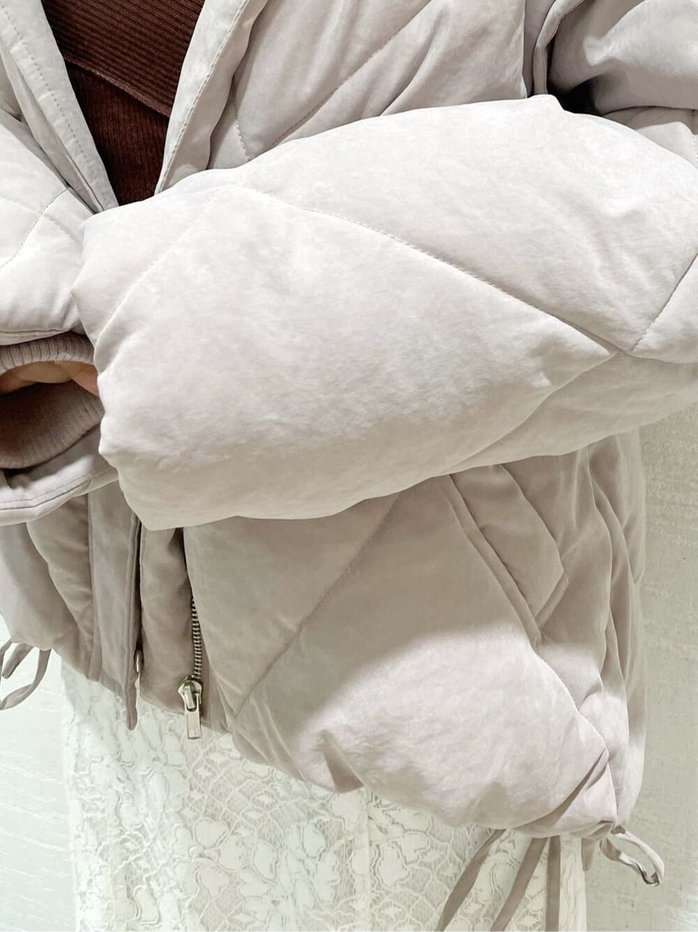 ホワイト系のスカート、ピンク系のダウンジャケット/コート、ブラウン系のニット/セーターを着用したレディースの夏コーディネートの6枚目の写真