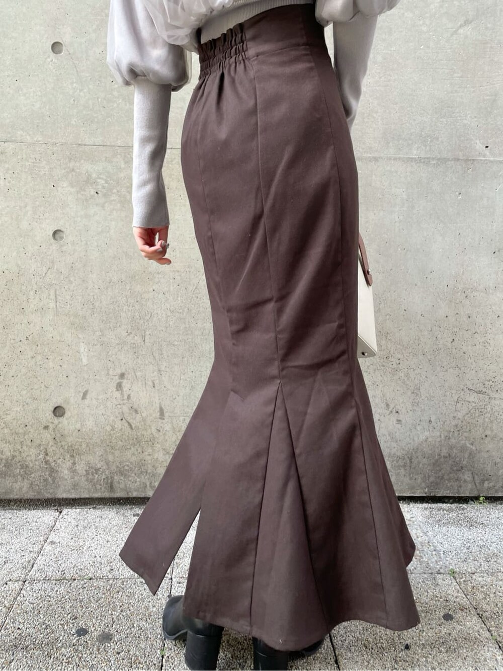 グレー系のニット/セーター、ブラック系のブーツ、ブラウン系のスカートを着用したレディースの秋コーディネートの8枚目の写真