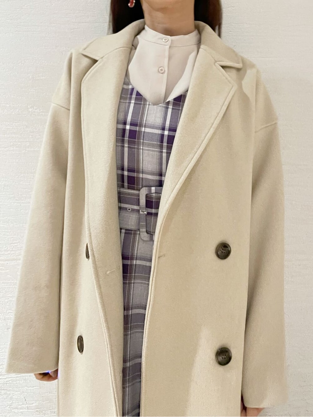 ブラック系のブーツ、ホワイト系のチェスターコート、パープル系のジャンパースカートを着用したレディースの冬コーディネートの8枚目の写真